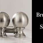 Two metallic spherical finials on a marble surface beside a black panel reading 'Brushed vs Satin'—a finishes comparison image.