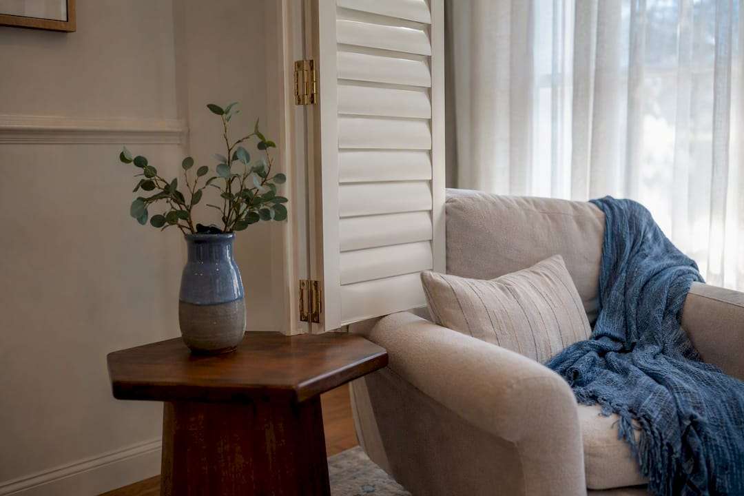 Open plantation shutter panel near furniture