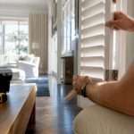 Hands installing plantation shutter panel