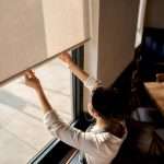 Hands adjusting roller shade in restaurant