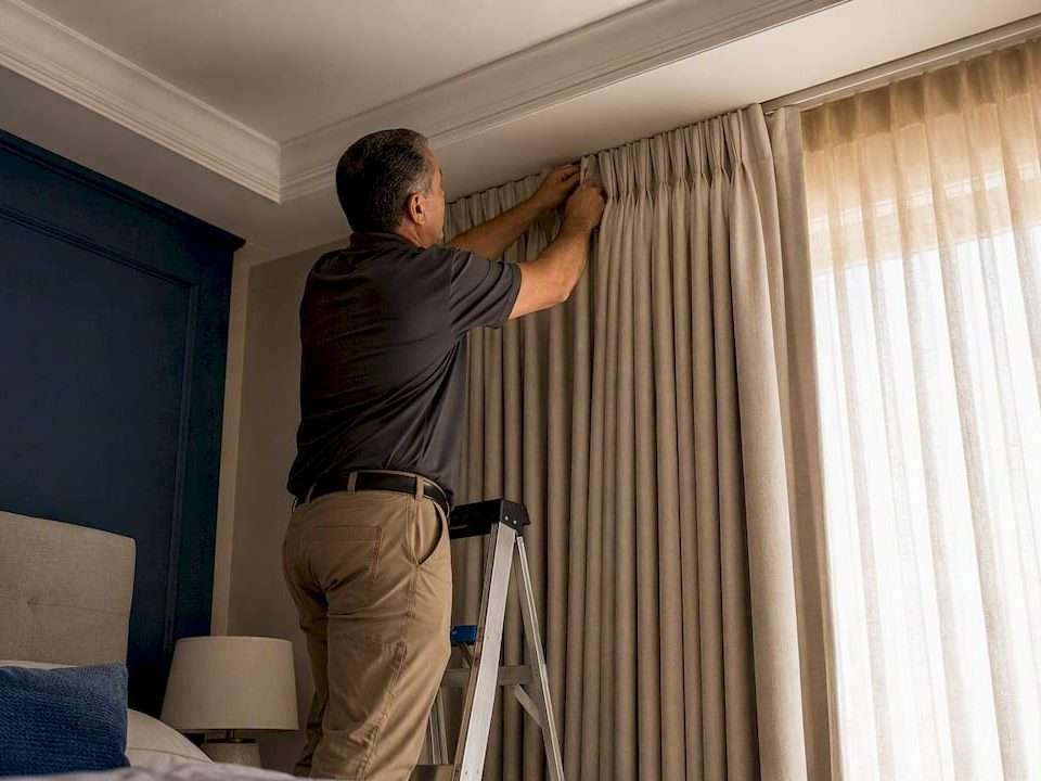 Installer attaching custom pleated drapery header