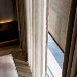 Layered window treatment edges in luxury interior