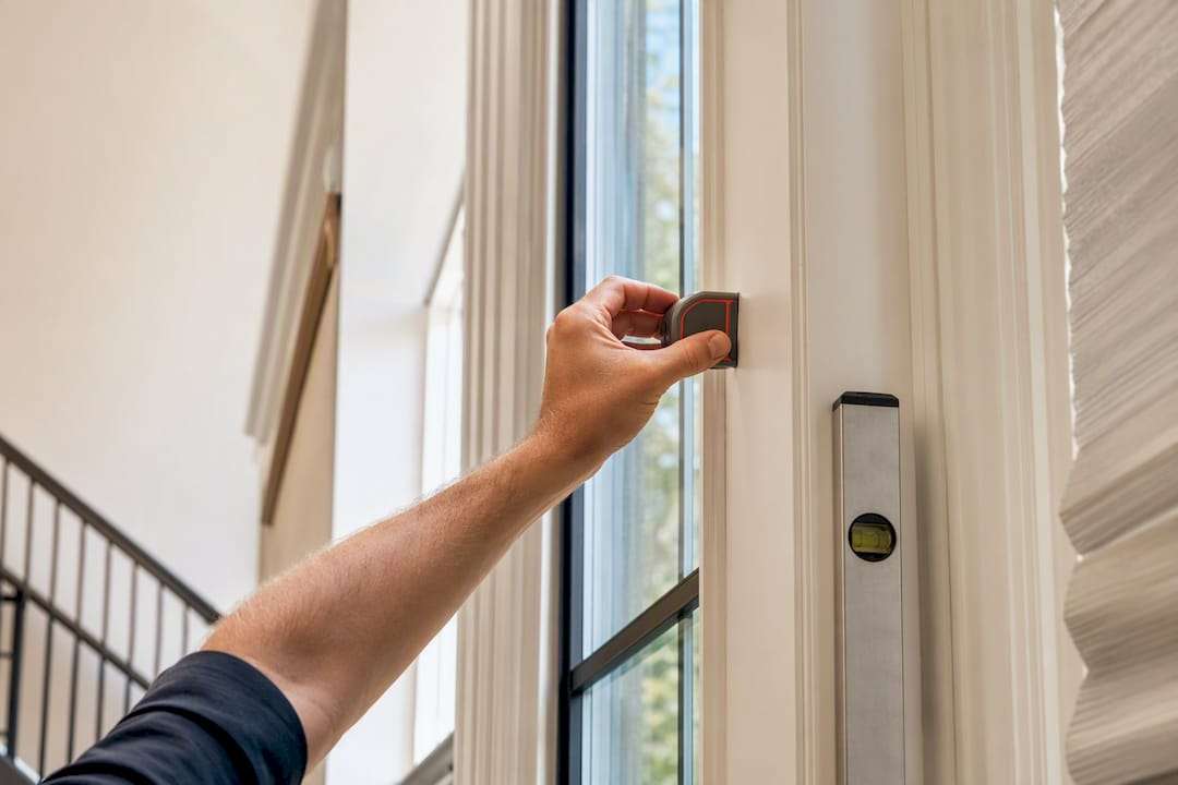 Installer checking tall window frame dimensions