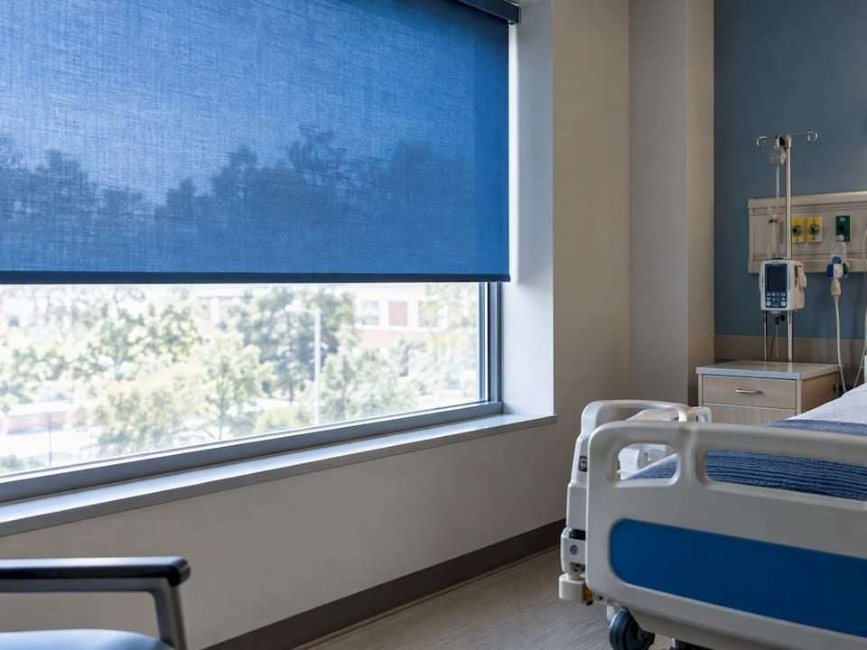 Blue window shade screening a hospital room