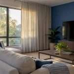 Drapery softens afternoon light near a television
